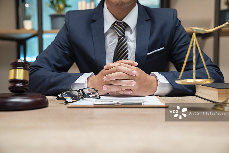 在法庭白色木桌上处理合同文件的男性法官图片素材