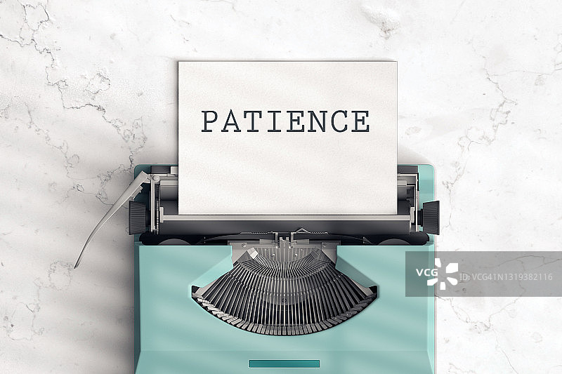旧蓝色打字机与纸上的“耐心”字样图片素材