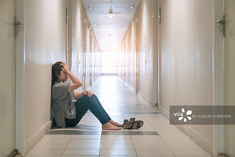 坐在走廊里哭泣的抑郁妇女图片素材