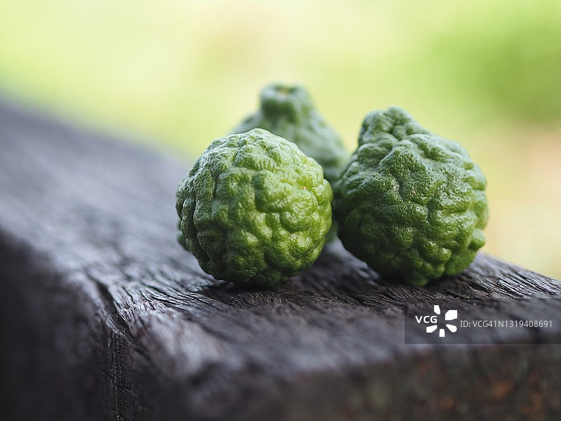 麻疯柑，粗皮绿皮蔬菜，木质背景图片素材