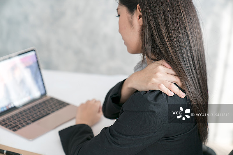 努力工作的女性肩部疼痛图片素材