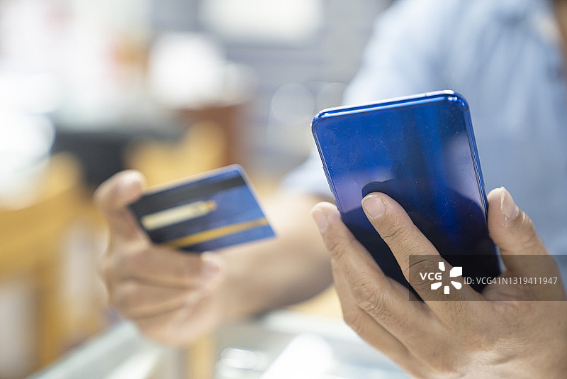男人手持信用卡进行在线支付图片素材