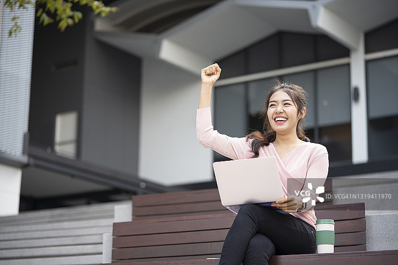 年轻亚洲女性手提电脑成功喜悦的肖像图片素材
