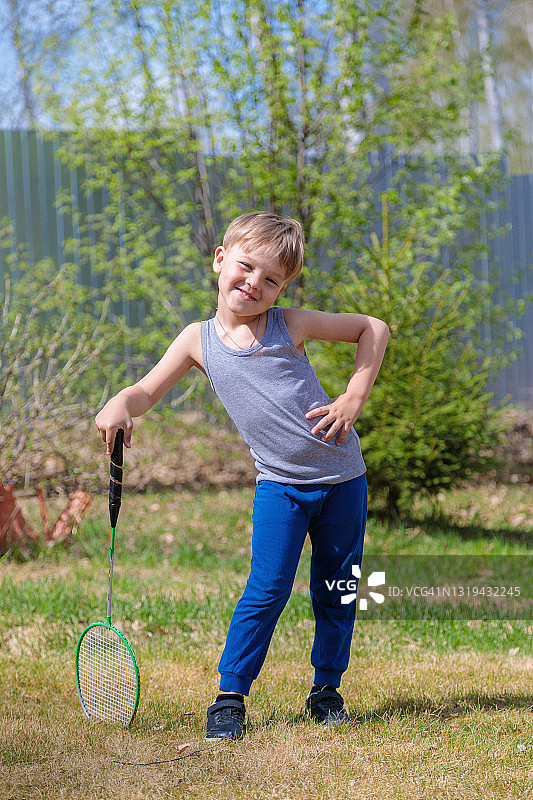 草坪上玩羽毛球的金发儿童图片素材