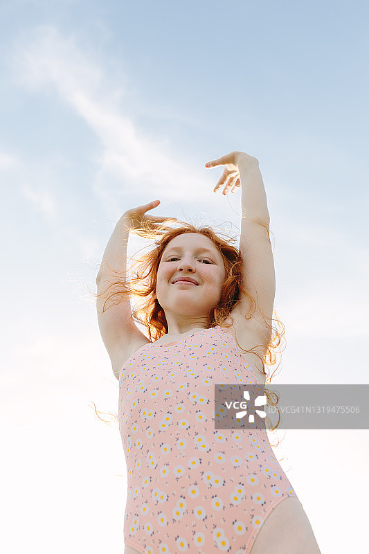 向天空伸出双手的红发女孩图片素材