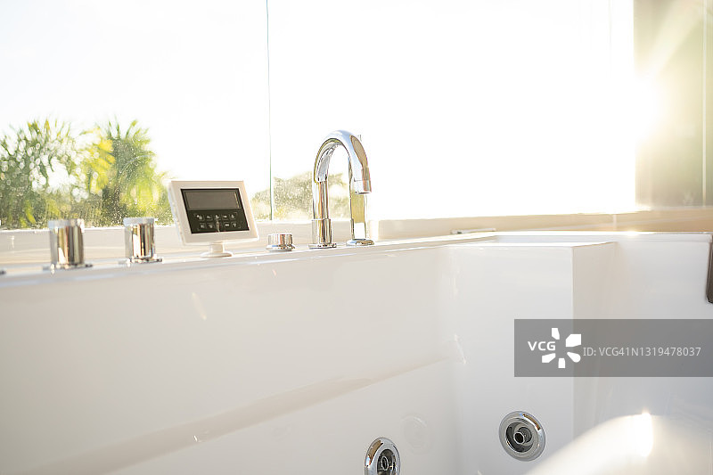 豪华浴室中的白色陶瓷水槽，电器和室外花园图片素材