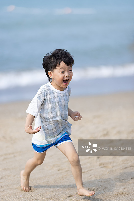 亚洲男孩在海滩上玩耍图片素材