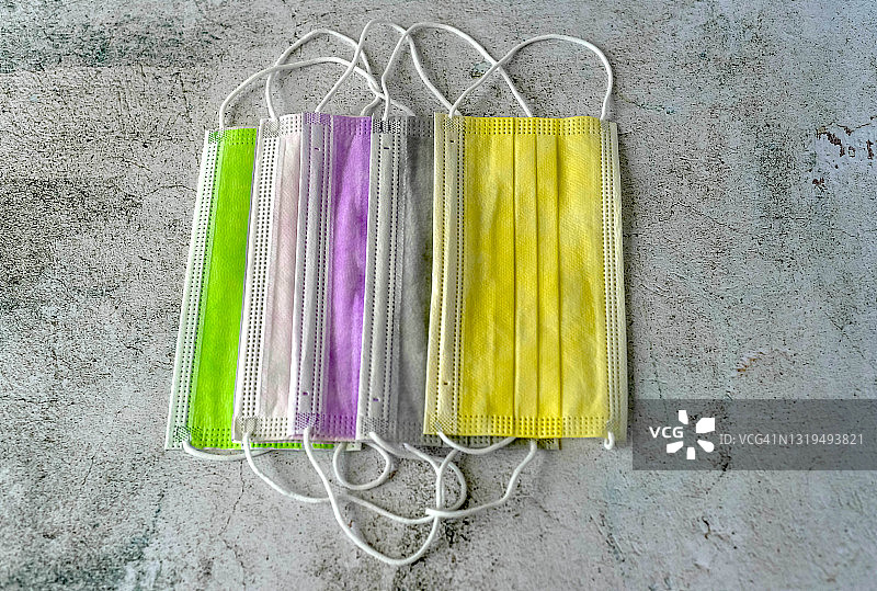 俯视：灰色背景上的彩色口罩图片素材