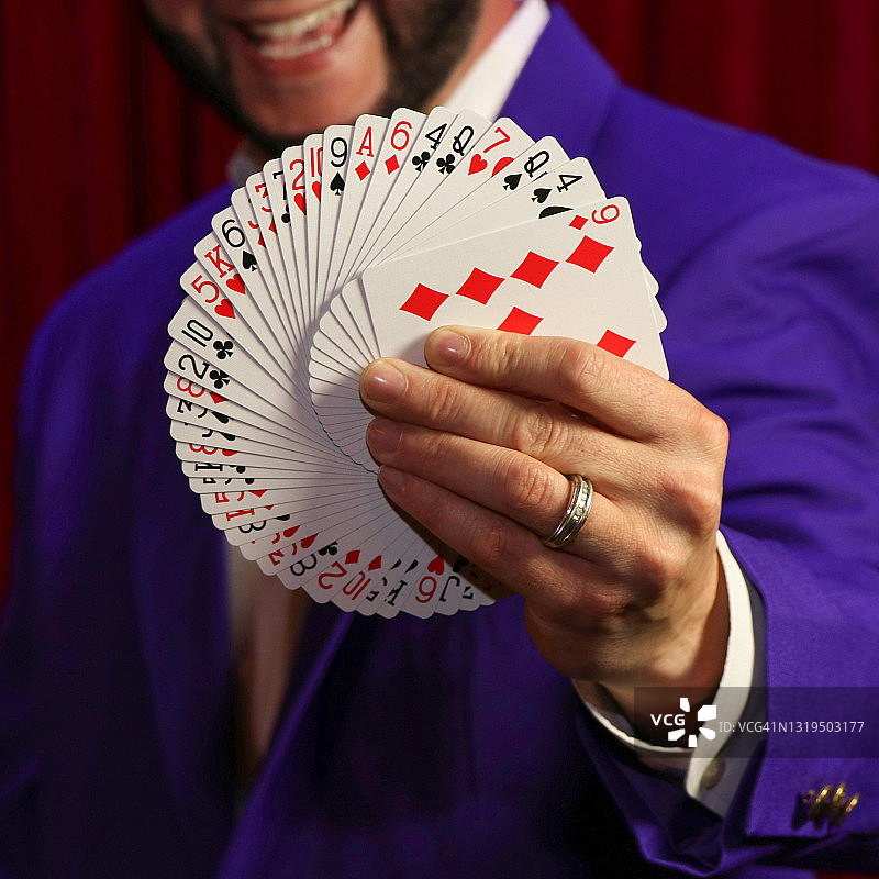 快乐的魔术师展示扑克牌图片素材