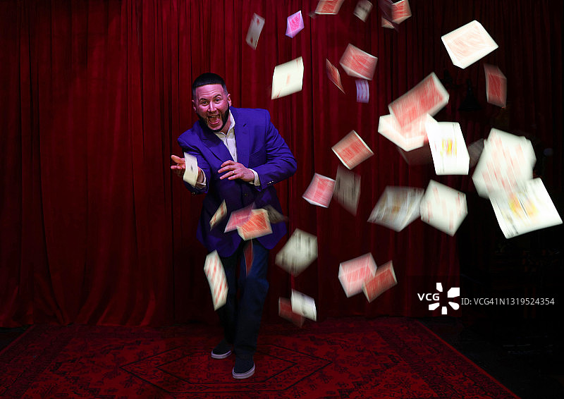 舞台上抛纸牌的魔术师图片素材