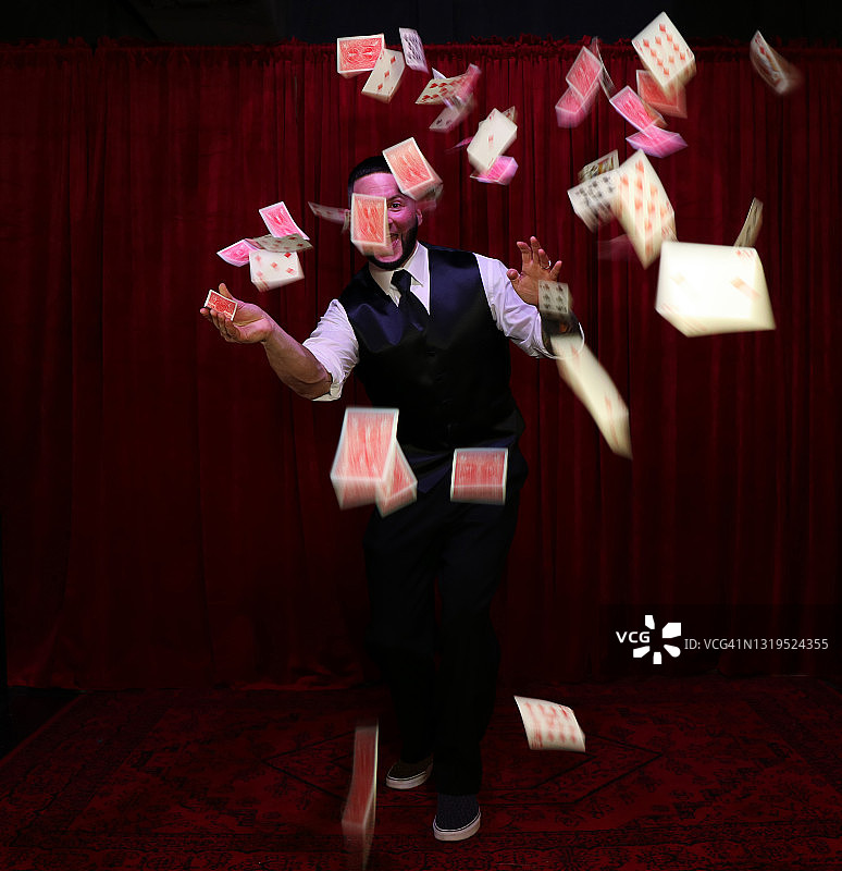 魔术师在空中扔扑克牌图片素材