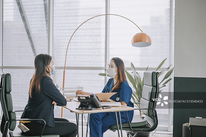 中国女医生在办公室向女病人解释X光片图片素材