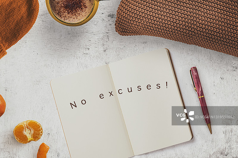 写在笔记本上的“没有借口”字样，女性桌面，带咖啡杯和笔图片素材
