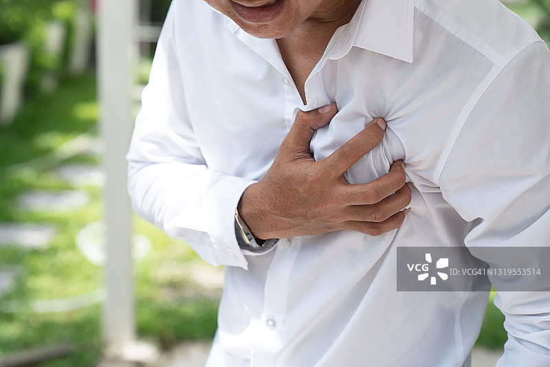 男子因剧痛而紧抓胸口。心脏病发作症状-医疗保健概念。图片素材
