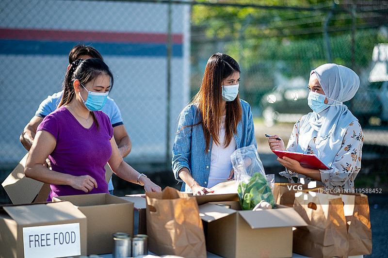 志愿者在慈善食品银行打包捐赠箱图片素材