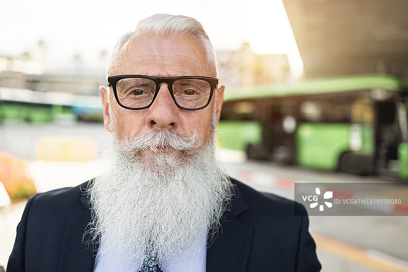 在公共汽车站等候的时尚老年商务男士，面部特写图片素材