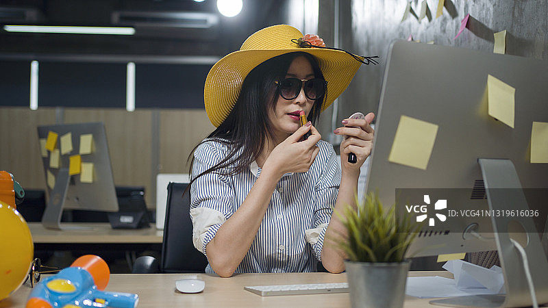 在桌前化妆的有趣的年轻女人图片素材