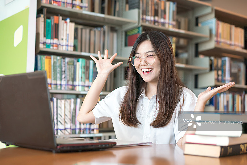 亚洲女性用笔记本电脑庆祝成功概念，教育图片素材