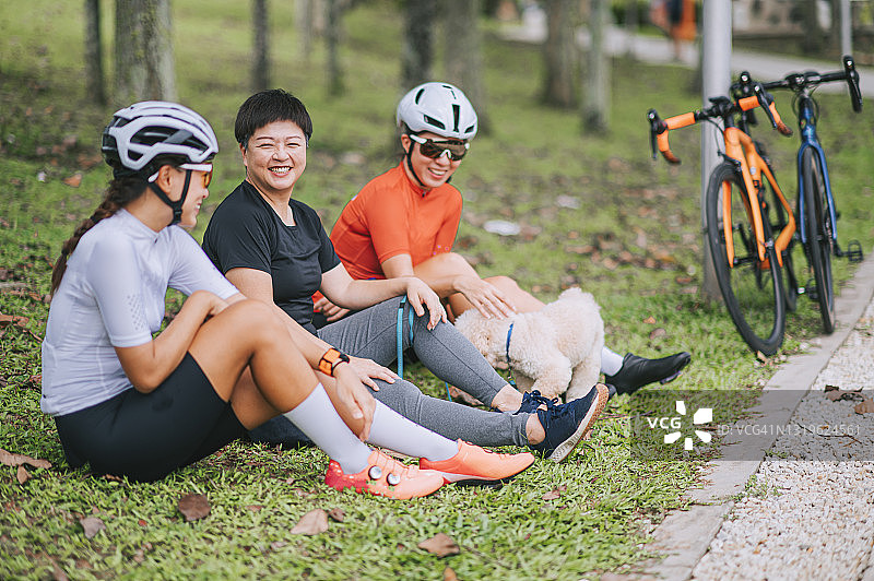 亚洲女子和她的宠物贵宾犬在公园里与朋友们 bonding图片素材