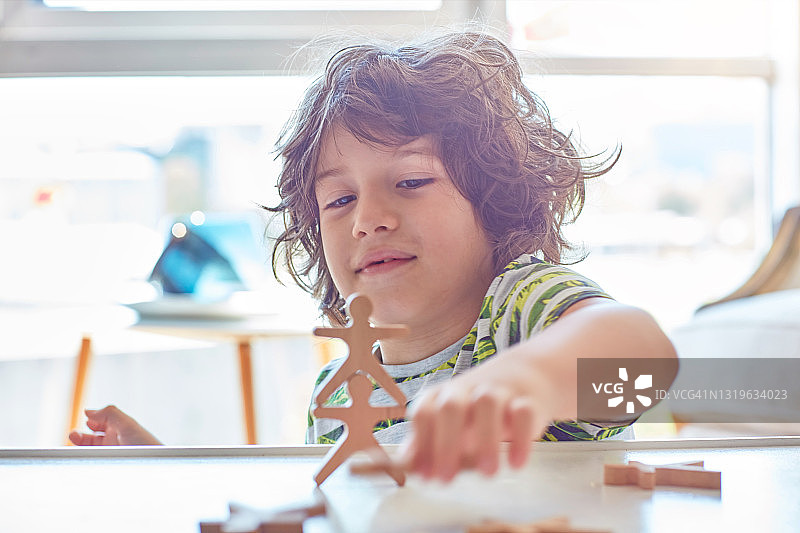 快乐的小男孩在家玩积木搭塔图片素材