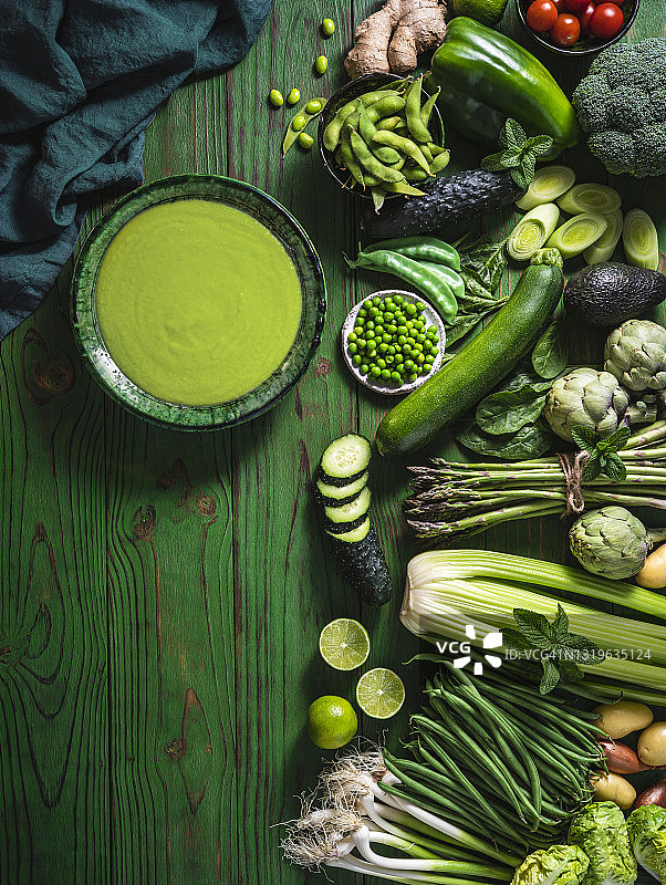 绿色木桌上的纯素生蔬菜配绿芦笋汤或豌豆汤图片素材