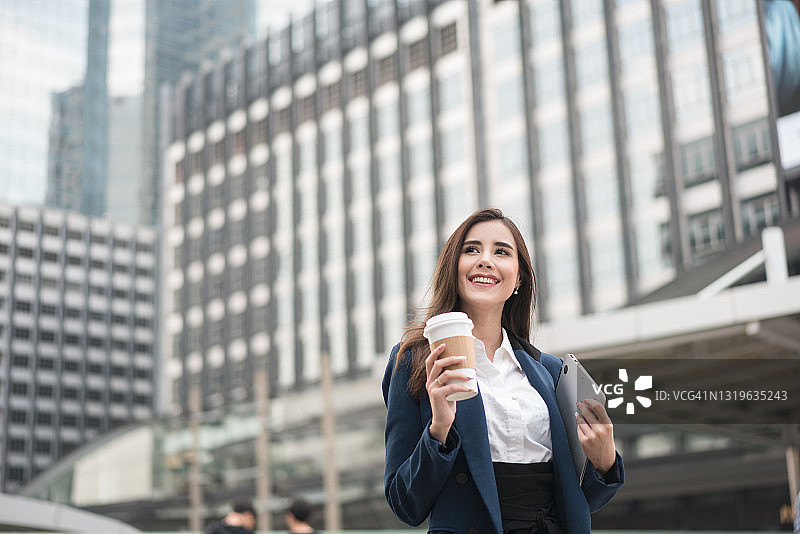 在上班途中，手持热饮杯的成功女商人肖像（高分辨率）图片素材