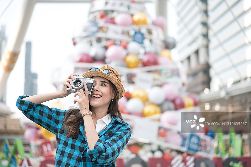 使用复古相机拍摄的时尚摄影师，捕捉瞬间的旅行女孩图片素材