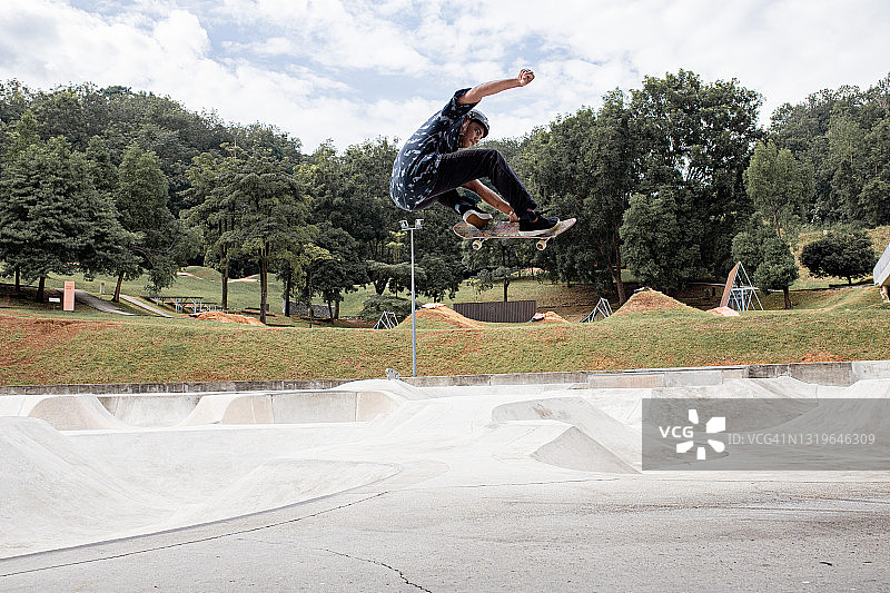 空中跳跃的亚洲滑板运动员图片素材