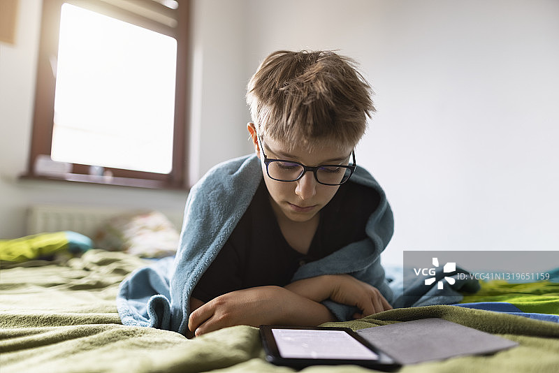 小男孩在家阅读电子书图片素材