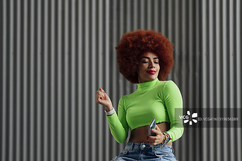 穿着露脐装在灰色墙前跳舞的女人图片素材