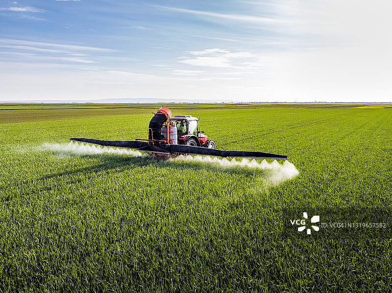 农民在田间用作物喷雾器给作物施肥图片素材