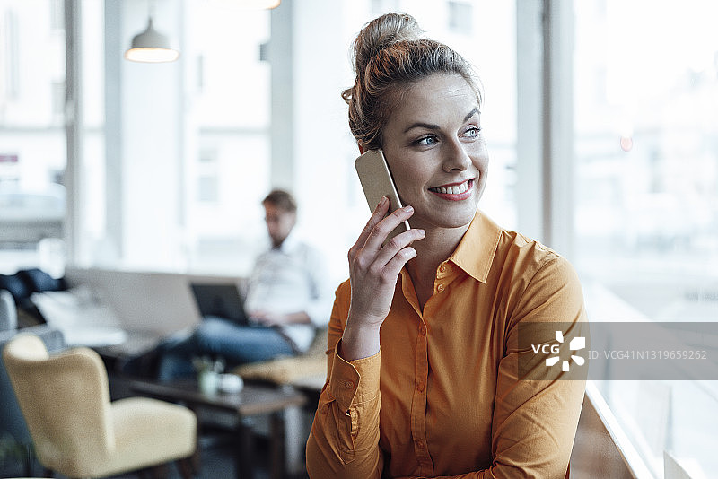 微笑企业家在咖啡馆打电话同事在背景图片素材