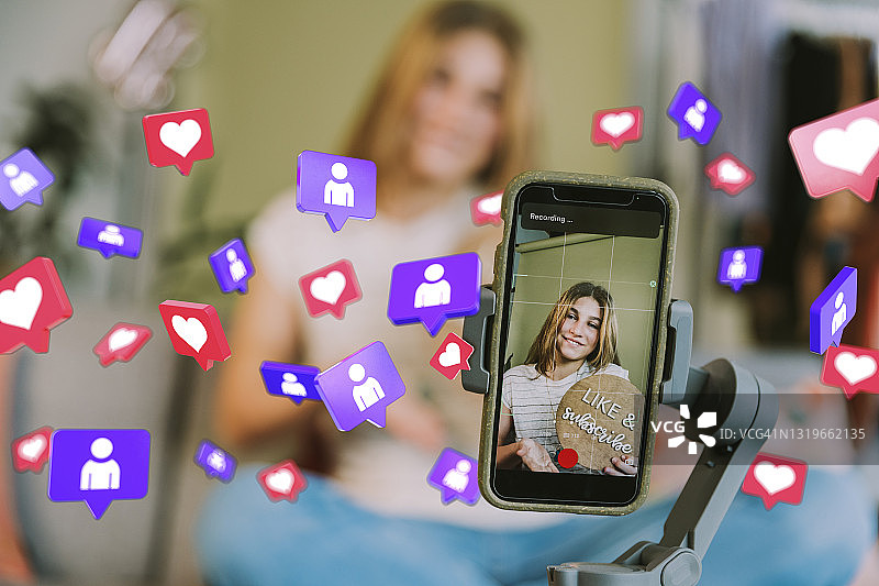 家中社交媒体图标背景下使用手机的微笑少女图片素材