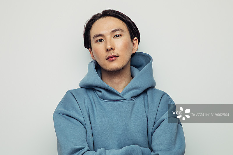 戴帽衫的亚洲男人表达情感图片素材