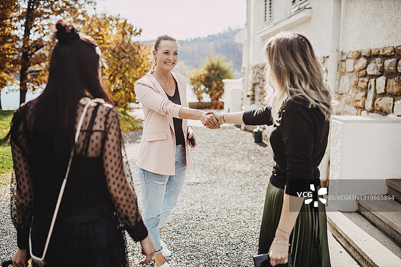 穿着时尚休闲装的美丽女人在握手图片素材