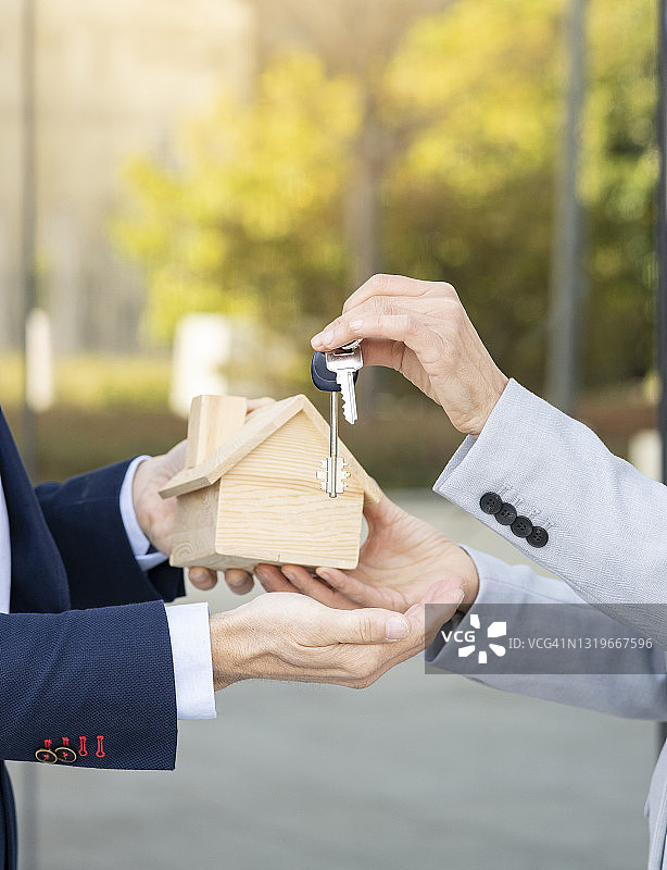 中年女商人从房地产开发商那里收到房屋模型和钥匙图片素材