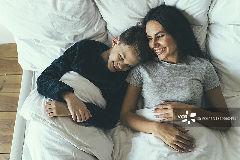 在家躺在床上微笑的儿子和母亲图片素材