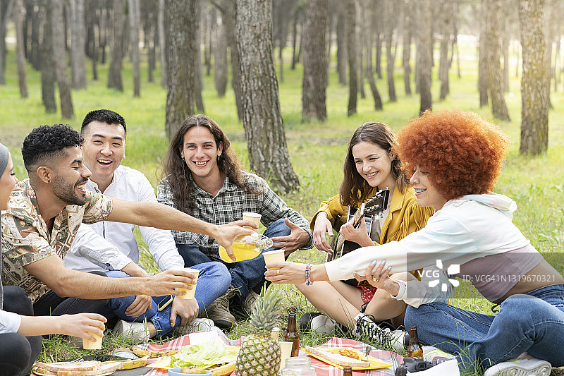 朋友们在森林野餐派对中玩乐图片素材