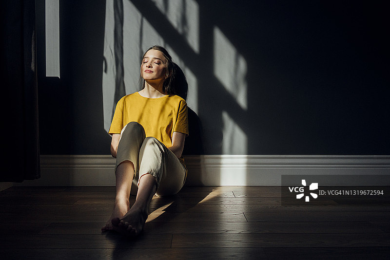 闭着眼睛坐在地板上的女人图片素材