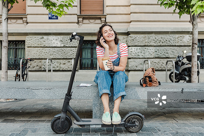 骑电动滑板车休憩打电话图片素材