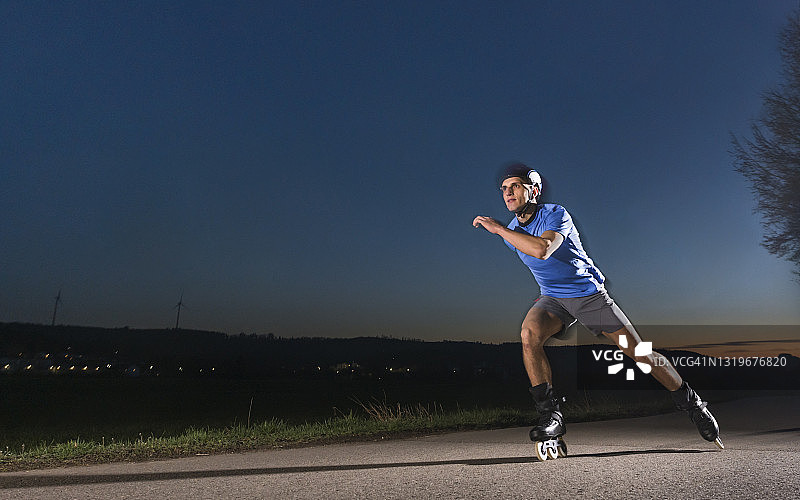 年轻男人在黄昏时在路上速滑图片素材