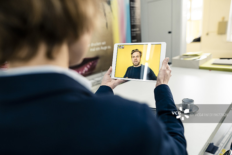 女商人通过数字平板电脑上的视频通话与同事在行业中合作图片素材