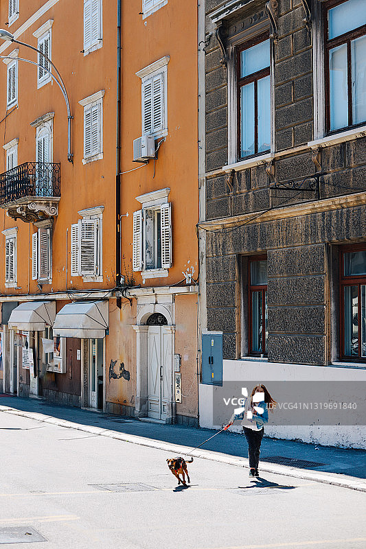 女孩在克罗地亚里耶卡街头遛狗图片素材