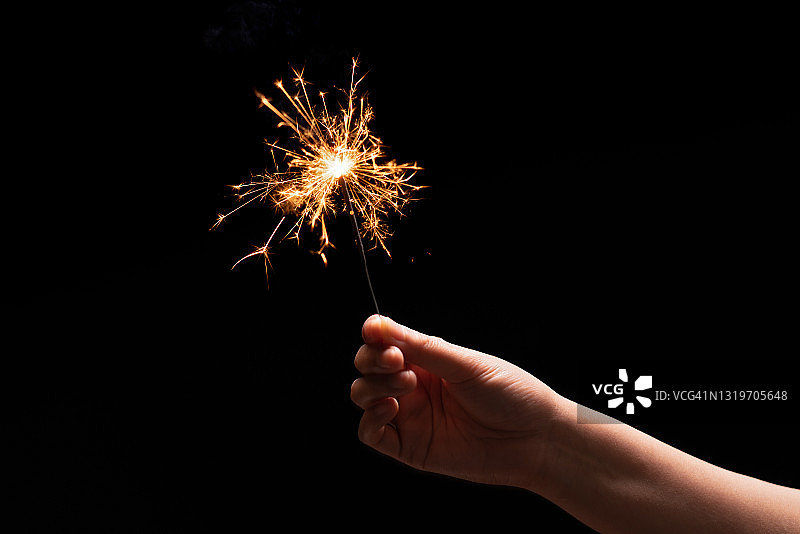 夜晚手持燃烧的烟花棒图片素材