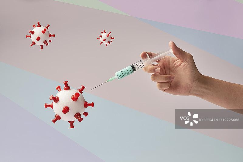 手工制作的新冠病毒模型和疫苗注射器图片素材