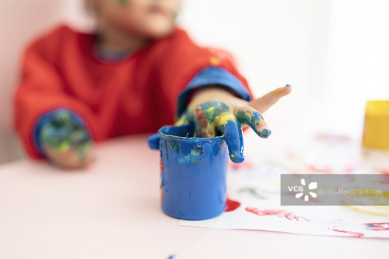 可爱的小女孩正在用手指绘画图片素材