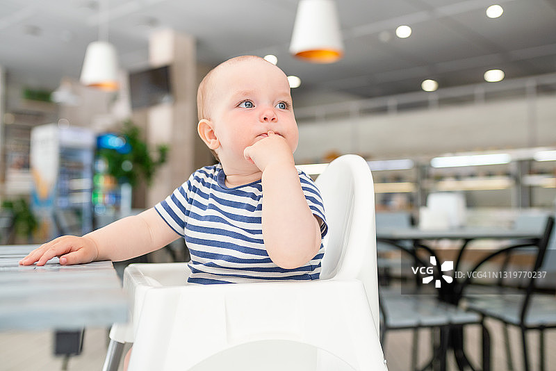 在高脚椅上的可爱微笑的小男孩图片素材