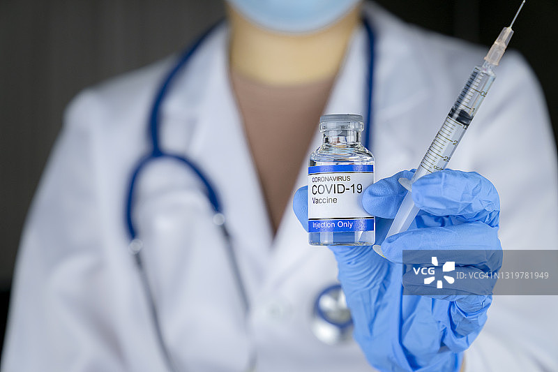医务人员展示新冠疫苗测试样品瓶图片素材