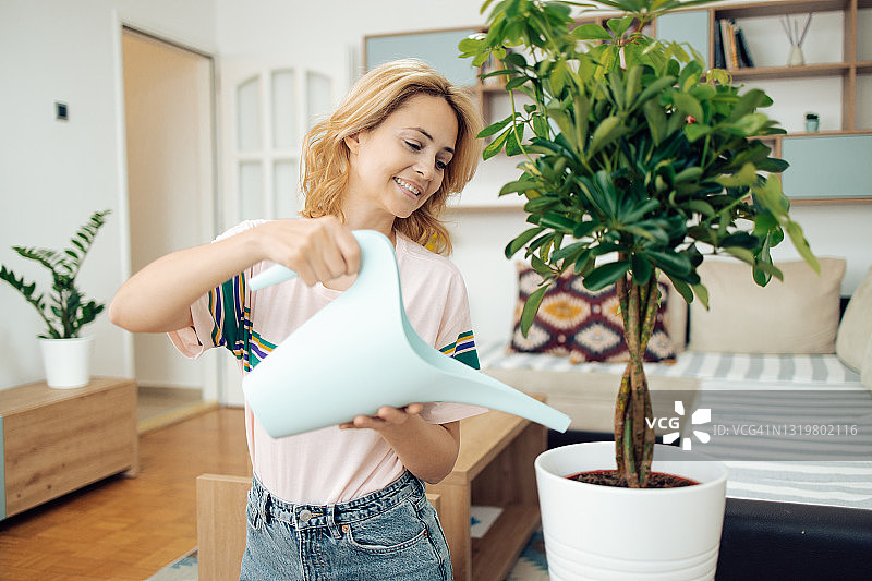 女人在家浇水植物，享受生活图片素材
