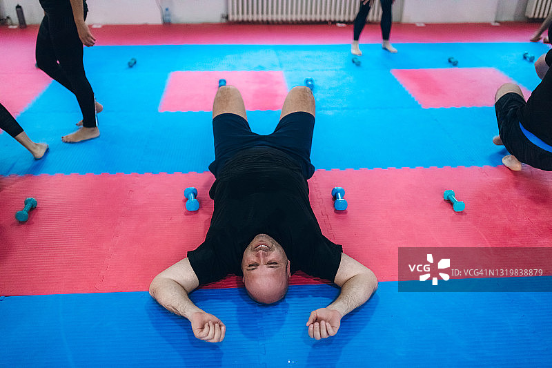 在健身房努力训练的超重男人图片素材